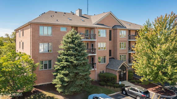 Front view of a multi-story brick apartment building with balconies.