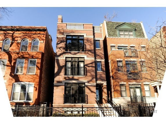 Front view of a multi-story brick building with balconies.