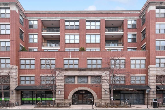 Front view of a multi-story brick building with balconies.