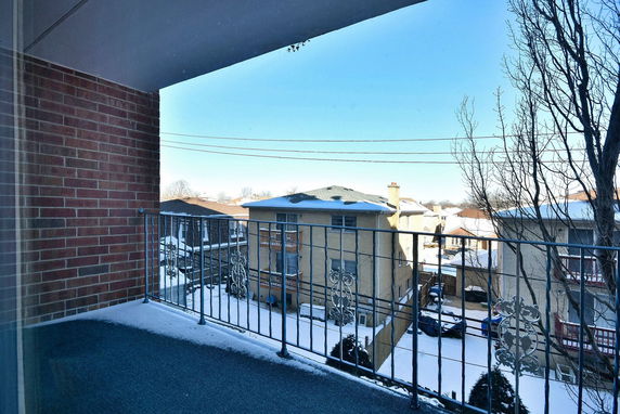 View from a balcony overlooking neighboring buildings in a snowy area.