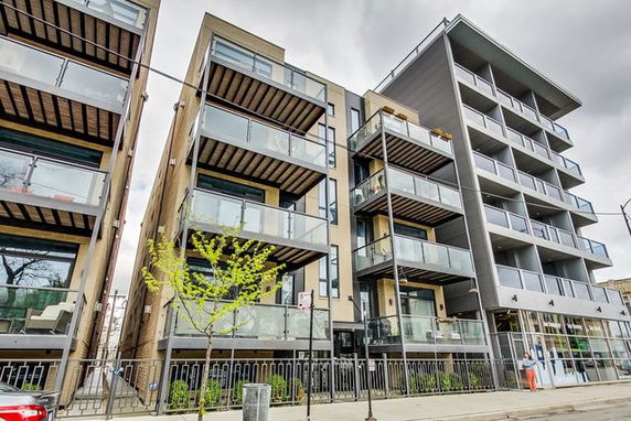 Front view of a modern multi-story apartment building with balconies.