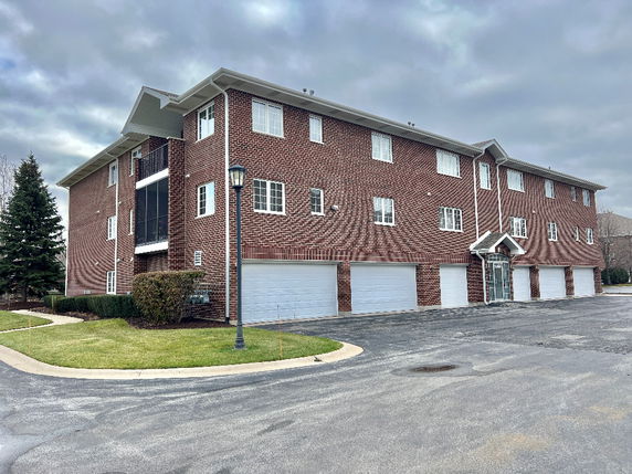 Front view of a multi-story brick building with multiple garage doors.