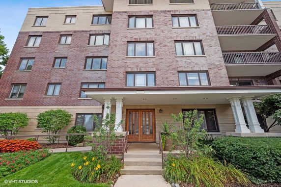 Front view of a multi-story residential building with brick and beige exterior.