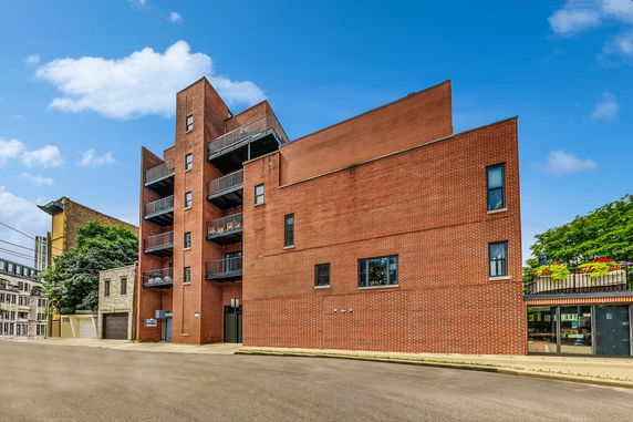 Front view of a multi-story brick building with balconies.