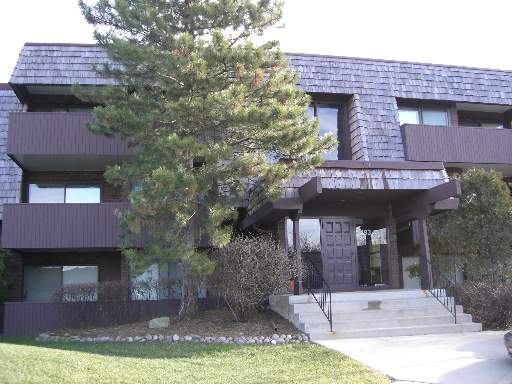 Front view of a three-story building with a distinctive dark exterior and a central entrance.