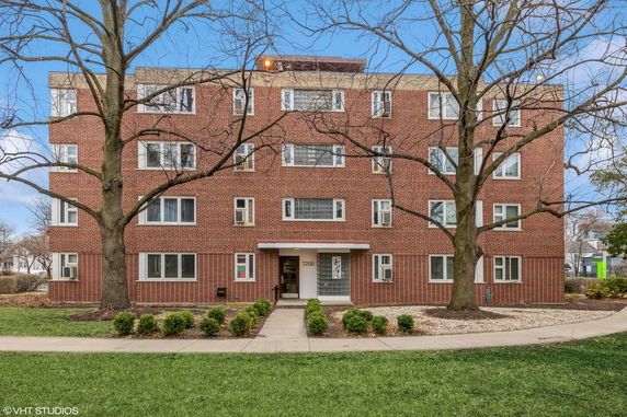 Front view of a multi-story brick building with multiple windows and a central entrance.