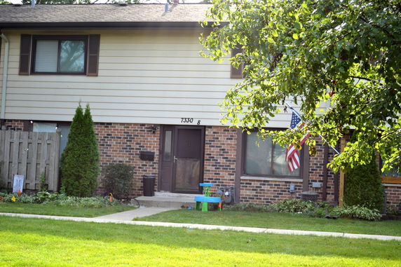 Front view of a two-story house with brick and siding exterior.