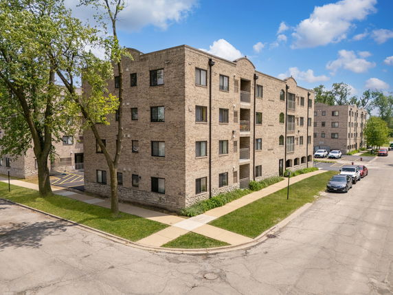 Front view of a multi-story apartment building with brick exterior.