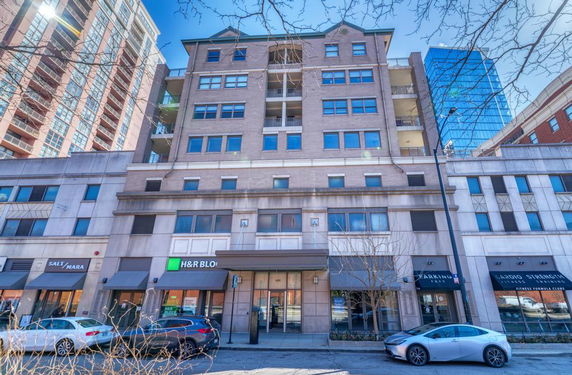 Front view of a multi-story building with storefronts on the ground level.