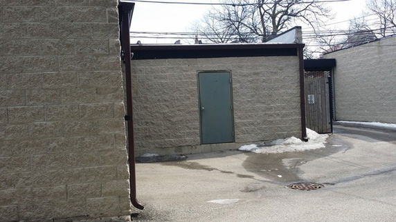 Exterior view of a building wall with a single door.