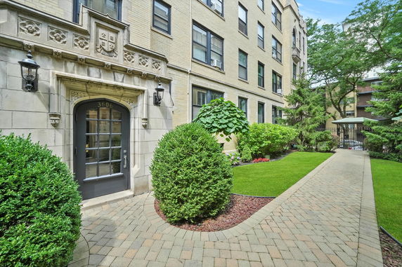 Front view of a multi-story brick building with detailed stone entrance.