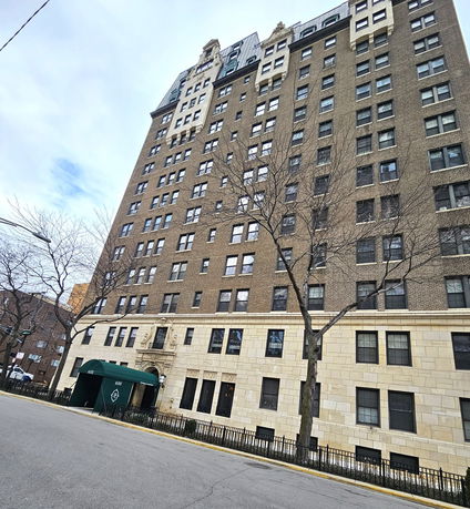 Front view of a multi-story apartment building with brick facade.