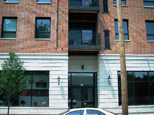 Front view of a multi-story brick building with balconies.