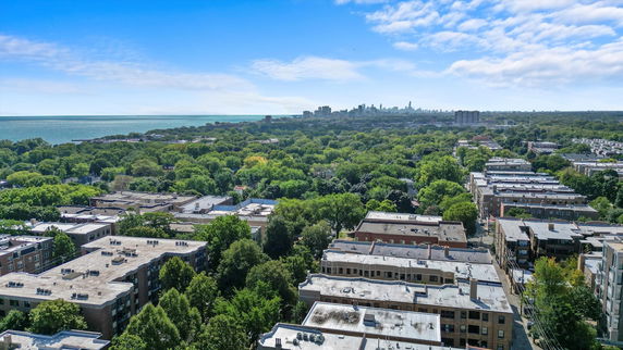 Panoramic view of urban landscape with greenery and distant skyline.