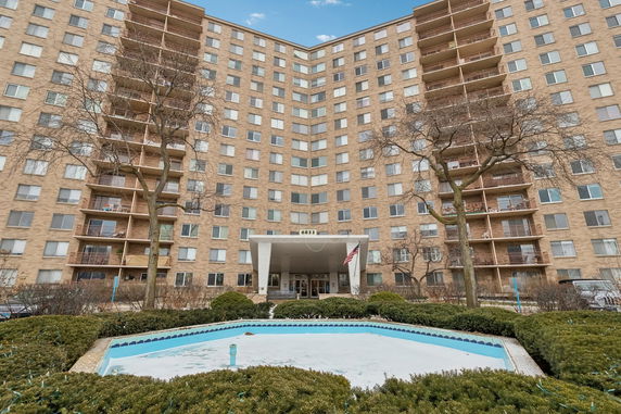 Front view of a multi-story residential building with balconies.