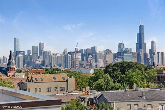 Panoramic view of a city skyline with various tall buildings and a church in the foreground.