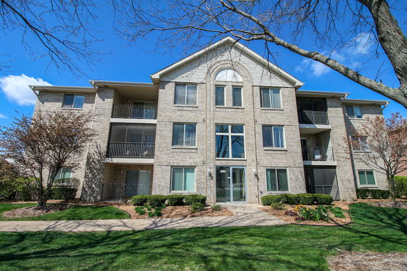 Front view of a three-story apartment building with balconies.