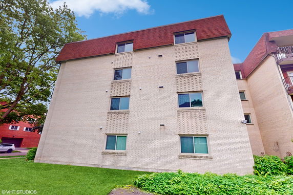 Front view of a multi-story building with brick exterior and multiple windows.