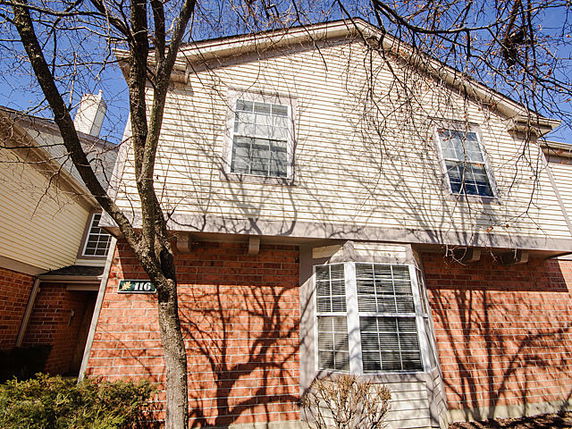 Front view of a two-story house with brick and siding exterior.