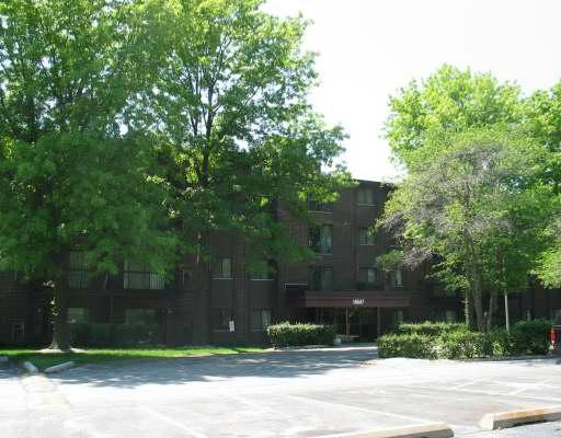 Front view of a multi-story building with a parking area in front.