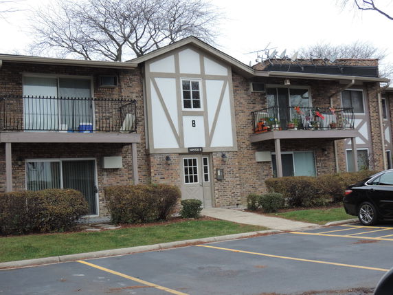 Front view of a two-story brick apartment building with balconies.