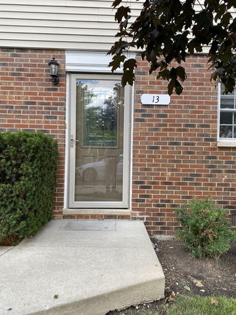 Front view of a house with a brick exterior and a glass door.