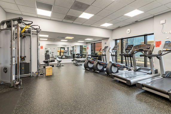 Interior of a gym with exercise equipment and treadmills.
