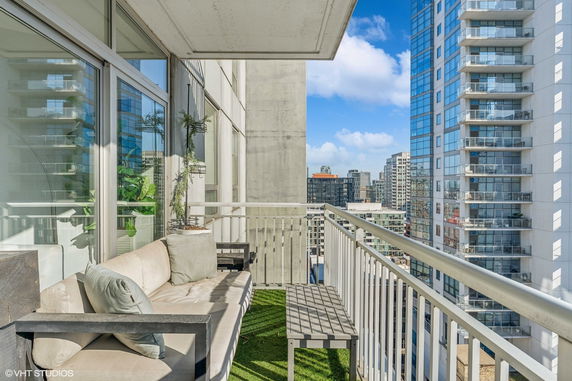 Balcony view overlooking city buildings with seating arrangement.