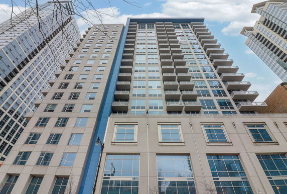 Front view of a tall residential high-rise building with balconies.