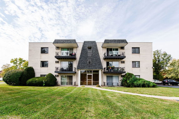 Front view of a multi-story apartment building with balconies.