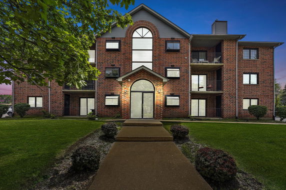 Front view of a multi-story brick building with balconies.