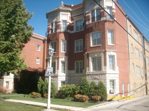 Front view of a multi-story brick building with decorative elements.