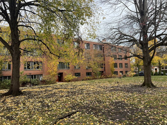 Front view of a multi-story brick building with multiple windows.