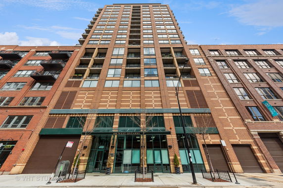 Front view of a multi-story residential building with brick facade.