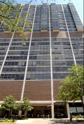 Front view of a tall multi-story building with large windows.