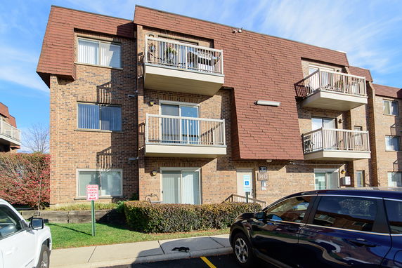 Front view of a brick apartment building with balconies.