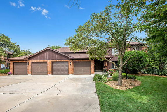 Front view of a house with a triple garage and brick exterior.