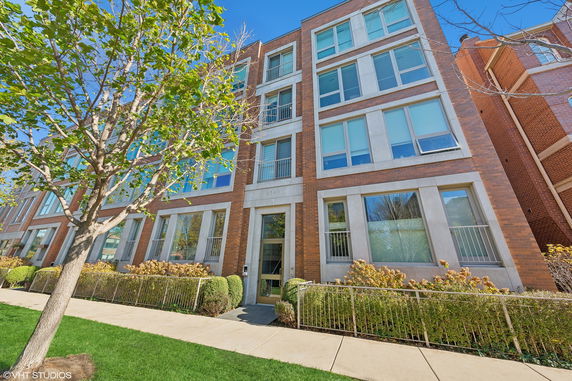 Front view of a multi-story building with brick and large windows.