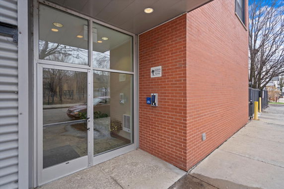 Front view of a brick building with a glass entrance door.