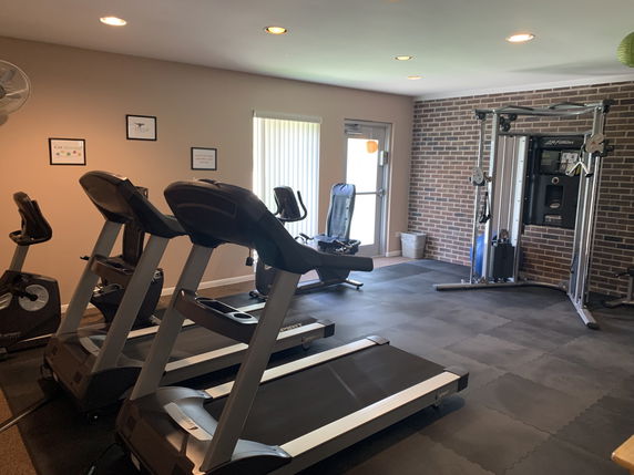 Interior view of a gym area with treadmills and exercise machines.