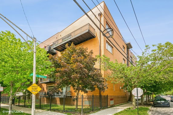 Front view of a multi-story brick building on a corner lot.