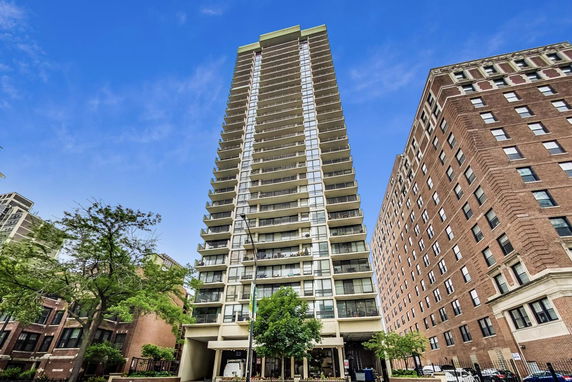 Front view of a tall residential building with multiple balconies.