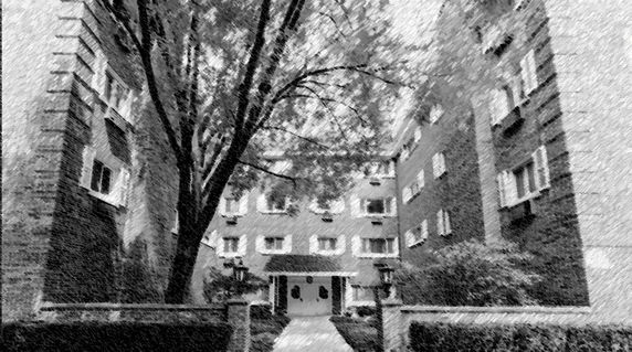 Front view of a multi-story apartment building with trees in the courtyard.