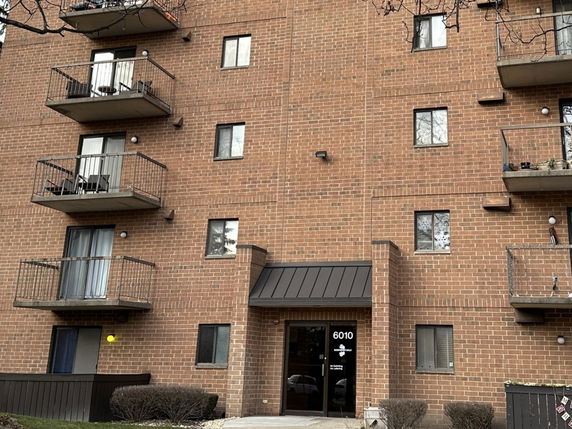 Front view of a multi-story brick building with balconies.