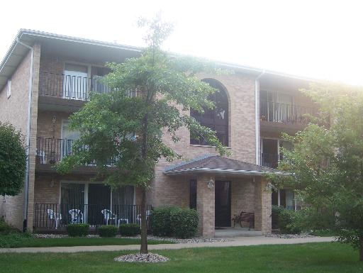 Front view of a three-story apartment building with balconies.