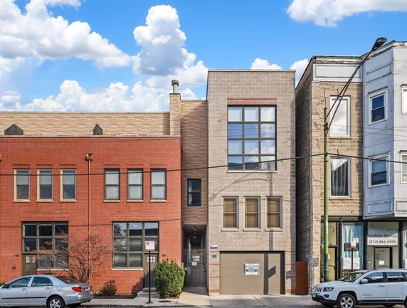 Front view of a multi-story building with brick and stone facade.