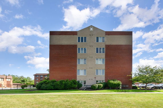 Front view of a multi-story brick and concrete apartment building.