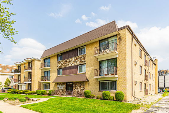 Front view of a multi-story apartment building with balconies.