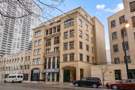 Front view of a multi-story building with commercial spaces on the ground floor.