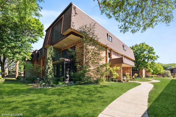 Front view of a multi-story building with a unique roof design and brick exterior.